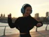 Mujer escuchando música con cascos en el paseo marítimo